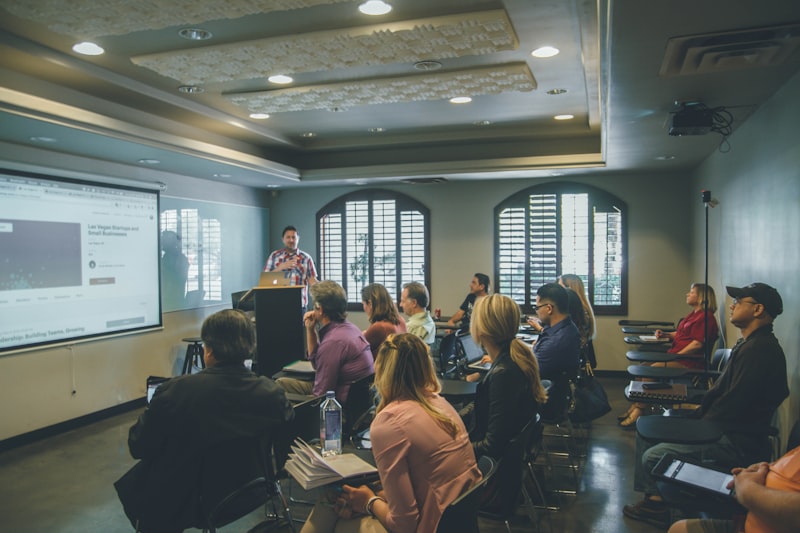 Educator presenting to an engaged audience in a dark auditorium